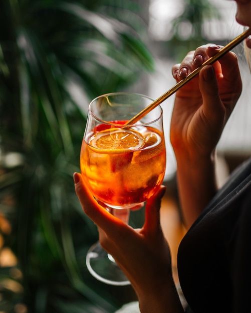 Photo femme buvant un cocktail aperol spritz avec une paille dans un verre