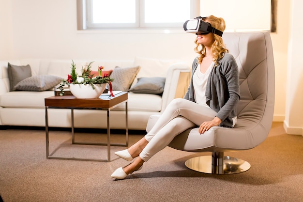 Femme portant des lunettes de réalité virtuelle dans la chambre