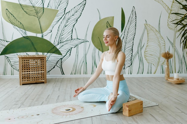 Une instructrice en forme s'entraîne sur un tapis de yoga dans un studio lumineux
