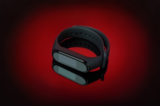 Photo montre intelligente noire pour le fitness sans icônes d'application avec réflexion sur fond dégradé rouge. montre-bracelet sans fil, dispositif d'innovation moderne.