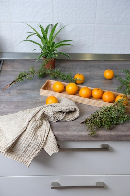 Mandarines sur une plaque en bois dans une cuisine blanche. Ambiance du Nouvel An, les vacances arrivent