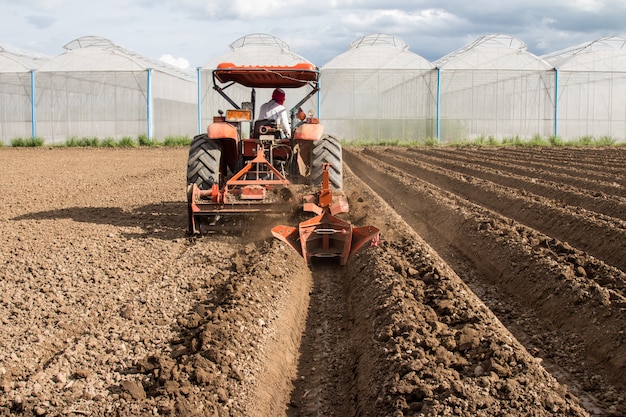 Photo sol de préparation de tracteur travaillant dans l'agriculture de champ.
