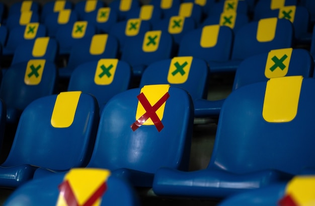 Siège avec autocollant symbole rouge placé sur une chaise en public pour un siège d'autres personnes garder la distance