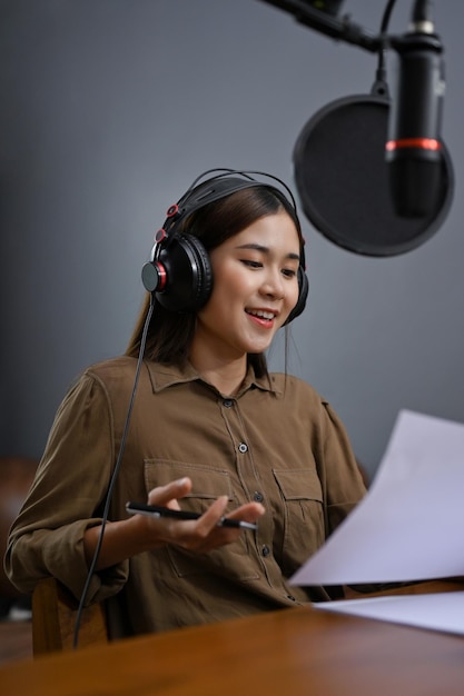 Portrait Belle femme asiatique enregistrant son contenu de podcast ou sa radio en ligne dans son studio