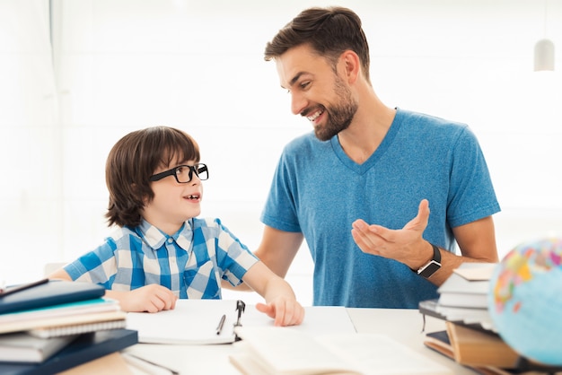 Le père aide son fils à faire ses devoirs à l'école.