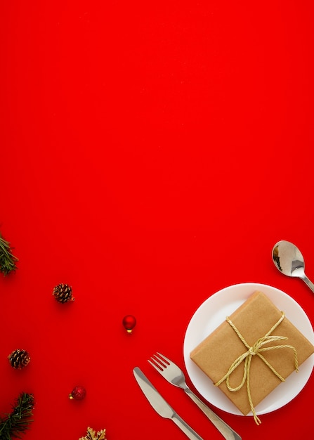 Table de Noël rouge avec assiette, coffret cadeau, couverts et décoration de Noël