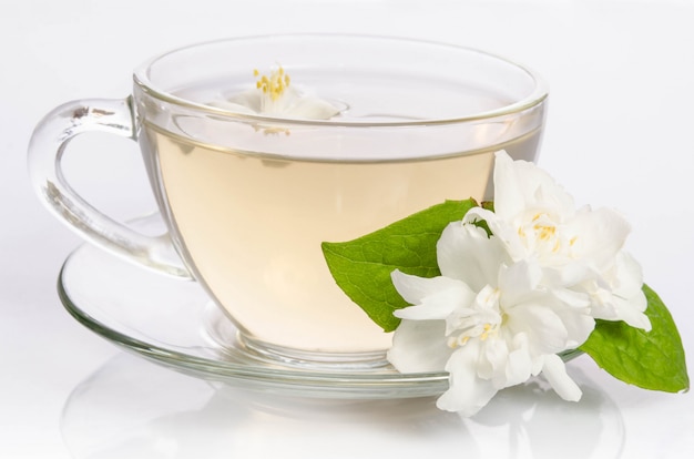 Photo tasse en verre de thé avec des fleurs et des feuilles de jasmin