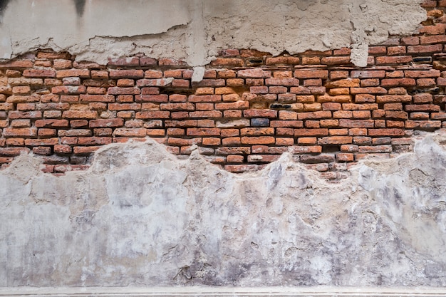 Texture de mur de brique ancienne vide. désintégration des murs voir brique rouge. Façade du bâtiment avec du plâtre endommagé.