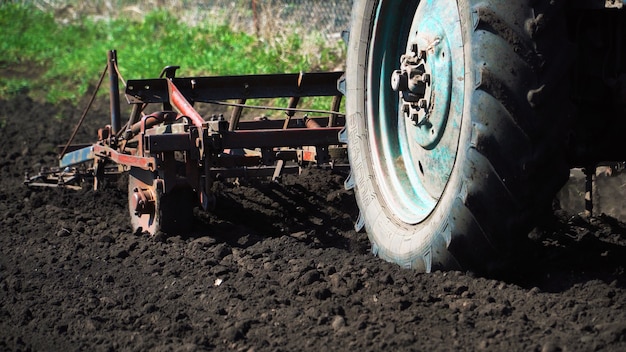 Photo le tracteur cultive et coupe des sillons dans le champ