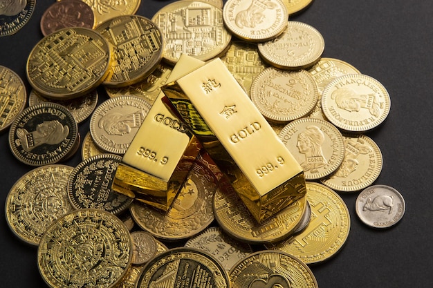 Monety i sztabki złota rozrzucone na stole