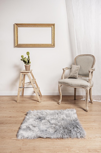 Zdjęcie nieoczyszczony lekki drewniany krzesło z szarym tapicerowanym siedzeniem trzystopniowa drewniana drabina z rośliną lekką drewnianą podłogą i parą pozłacanych drewnianych ram na ścianie