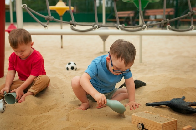 Zdjęcie pełne ujęcie dzieci bawiące się piaskiem