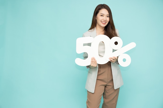 Zdjęcie portret kobiety azjatyckiego biznesu pokazano i posiadających numer 50 lub pięćdziesiąt procent na białym tle na jasnozielonym tłem