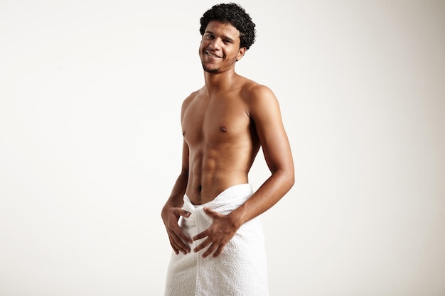 Uśmiechnięty mężczyzna po prysznicu nosi biały ręcznik