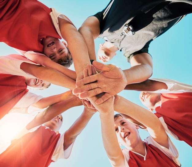 Zdjęcie współpraca rąk i dzieci z drużyną sportową razem stojące w skupisku lub kręgu od dołu fitness piłkarski i współpraca z motywacją dzieci przed grą lub meczem na świeżym powietrzu