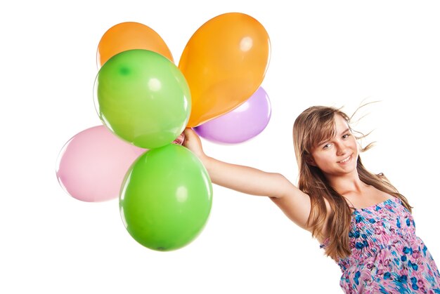 Фото Девочка-подросток играет с разноцветными воздушными шарами на белом фоне