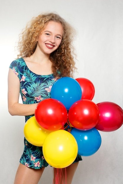 Фото Подростковая девушка с гелиевыми шариками на сером фоне