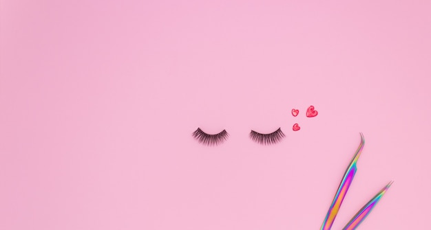 Photo tools and patches for eyelash extensions and artificial eyelashes on a pink background