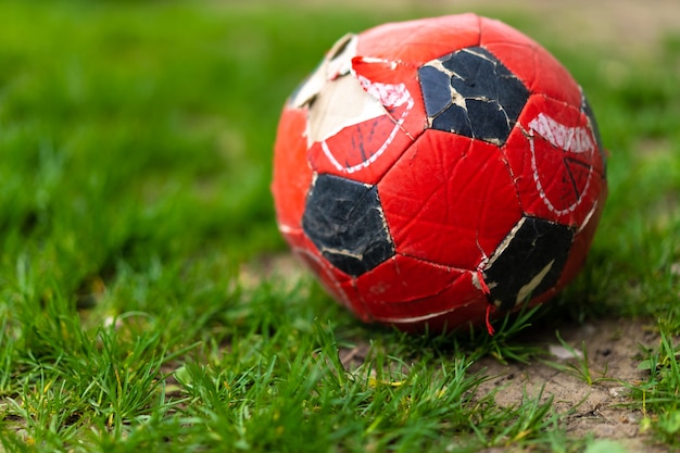 Разорванный футбольный мяч лежит на траве