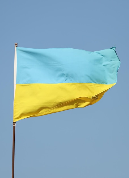 Фото Украинский флаг развевается на флагштоке