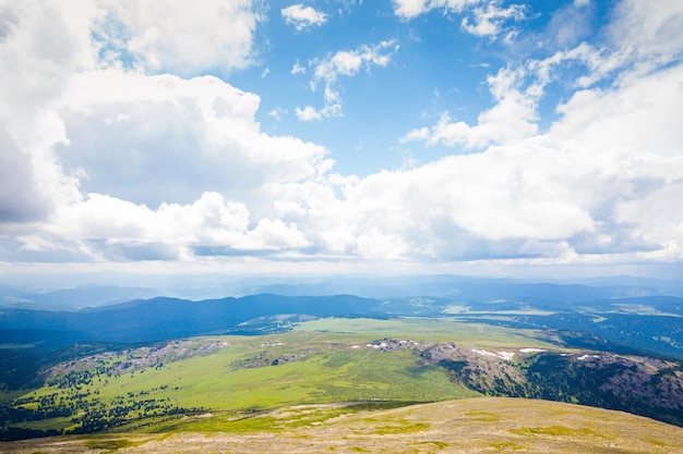 Фото Ультра широкая панорама горизонта. зеленые горы покрыты лесом на фоне голубого неба.