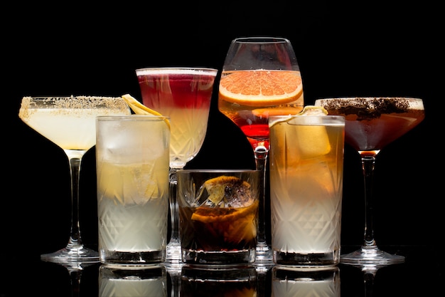 Foto verschillende soorten cocktails zijn geïsoleerd op een zwarte achtergrond.