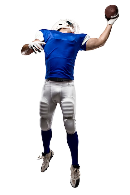 Foto voetballer die met een blauw uniform een vangst op een witte muur maakt