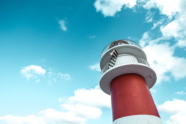 Wallpaper of a red and white lighthouse with copy space and seagulls flying, minimalistic