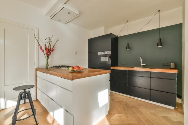 Photo a white kitchen with black cabinets and a bar stool