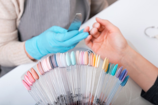 Photo woman choosing perfect color for her nails at salon