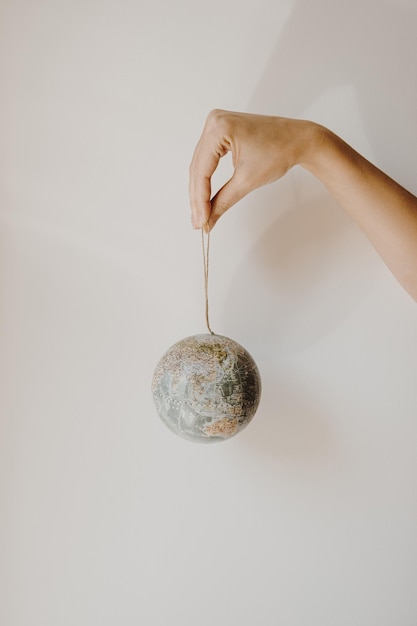 Woman hand hold small globe on white background World planet Earth model in hands Save the Earth and environment concept