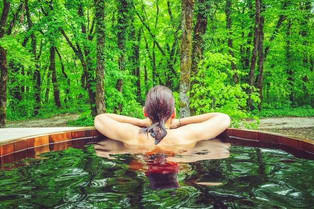 Woman in nordic bath in front of a forest