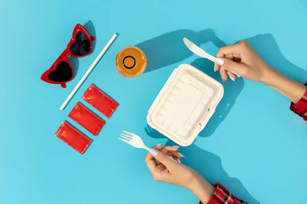 Womans hands with lunchboxes on blue table Food delivery concept