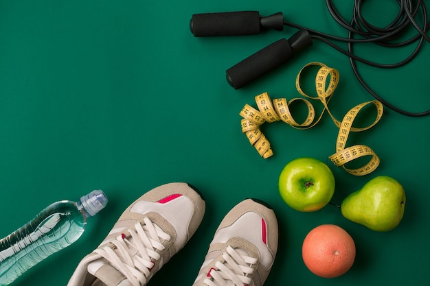 Фото План тренировки с фитнес-едой и оборудованием на зеленом фоне, вид сверху