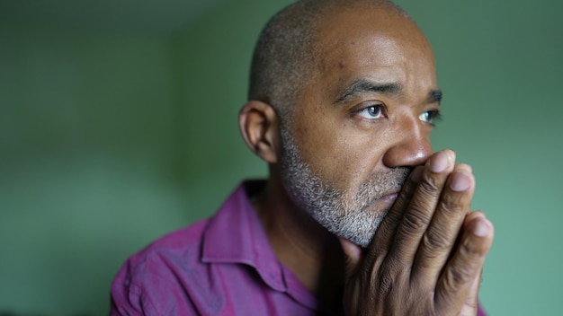 Photo a worried senior black man praying to god seeking help