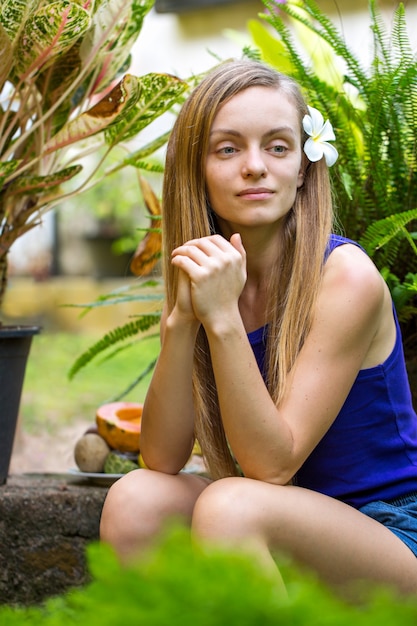 Photo young woman in the garden with tropical plants