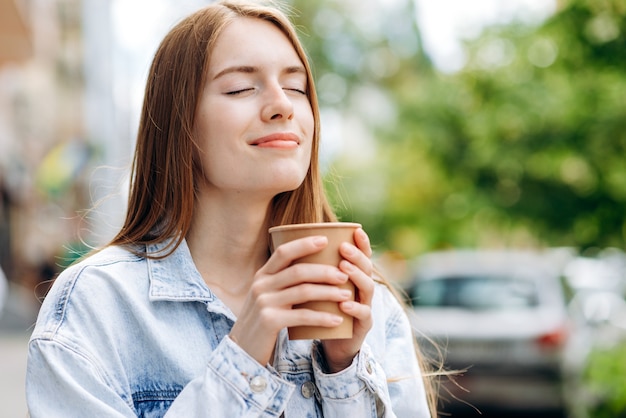 молодая женщина на открытом воздухе с чашкой кофе