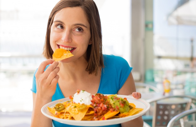 Photo young woman in a restaurant having nachos