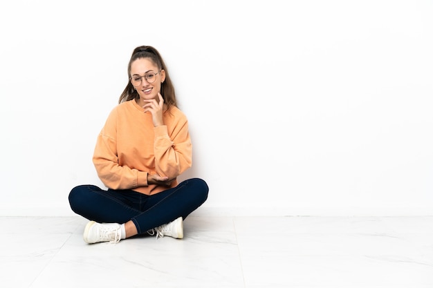 Photo young woman sitting on the floor laughing