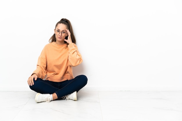 Photo young woman sitting on the floor thinking an idea