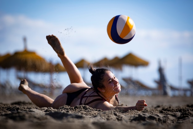 молодые женщины играют в пляжный волейбол