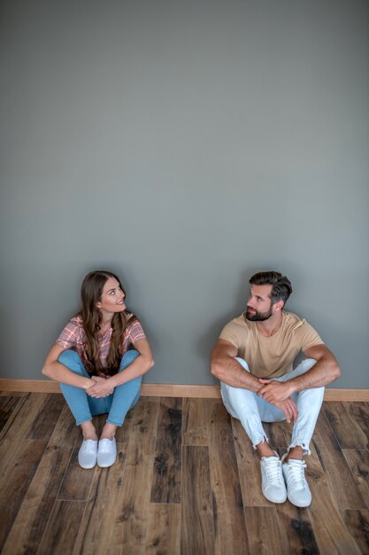 Photo young couple sitting on the floor in new home
