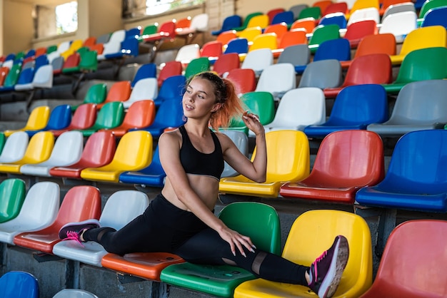 Молодая женщина-тренер занимается йогой на стадионе для здорового образа жизни