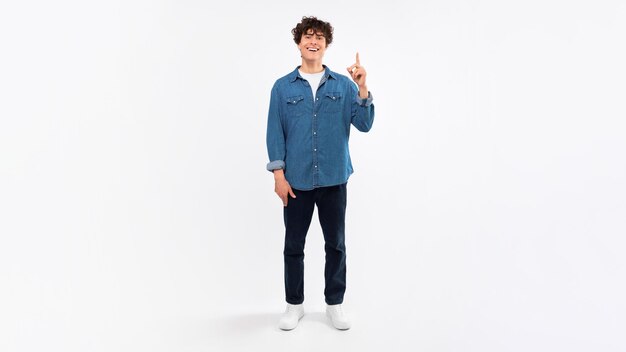 Photo young man having excellent idea pointing up over white background