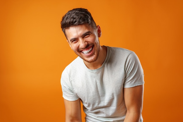Photo young positive man standing in blank white shirt laughing close up