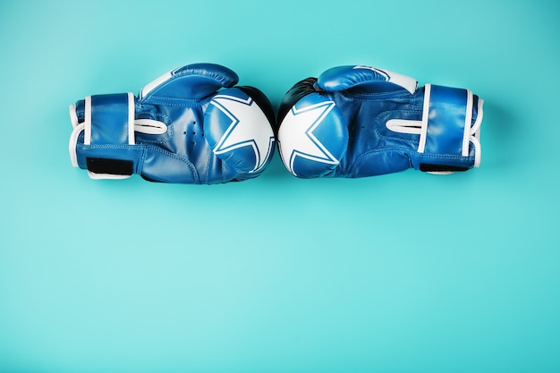 Фото Пара кожаных боксерских перчаток на синем фоне, свободное пространство.