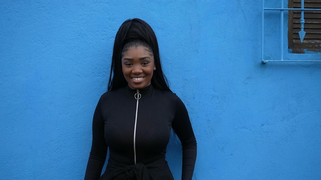 Фото Молодая чернокожая африканка, опирающаяся на портретное лицо на синем фоне