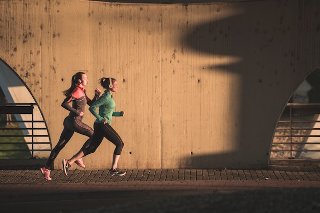 Photo active girls running at sunset