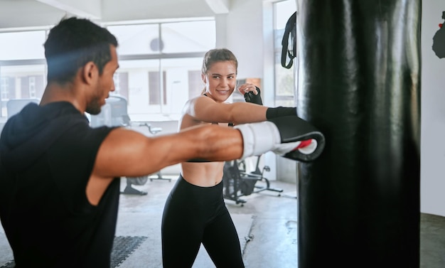 Photo active and fit man and woman boxing exercising and training together for fitness at the gym young sporty and serious couple doing a routine cardio workout and working out at a sports center