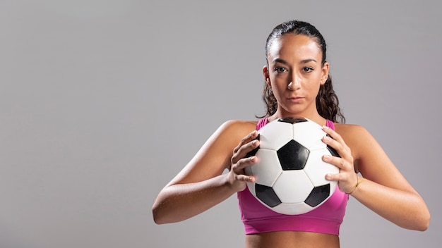 Взрослая женщина, держащая футбольный мяч